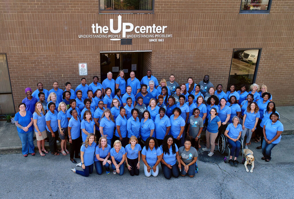 The Up Center group portrait outside under sign